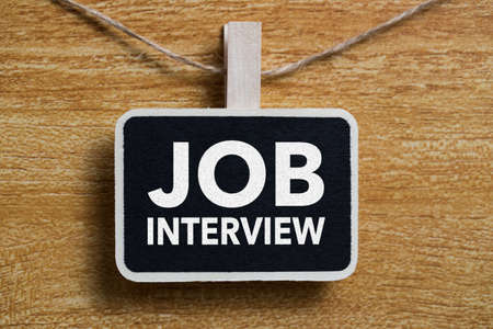 Job Interview text on blackboard sign board against wooden background.の写真素材