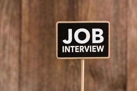 Job Interview text on blackboard sign board against wooden background.の写真素材