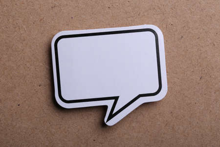 White blank speech bubble isolated on brown paper background with shadow.の写真素材