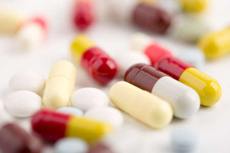 Assorted pharmaceutical medicine pills, tablets and capsules over white background.の写真素材