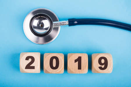 Stethoscope with 2019 wooden blocks on blue background.の写真素材