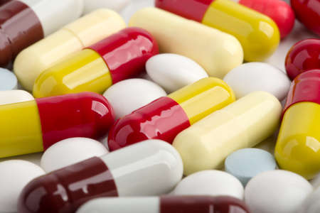 Assorted pharmaceutical medicine pills, tablets and capsules over white background.の写真素材