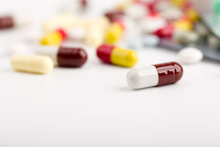 Assorted pharmaceutical medicine pills, tablets and capsules over white background.の写真素材