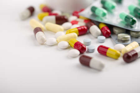 Assorted pharmaceutical medicine pills, tablets and capsules over white background.の写真素材