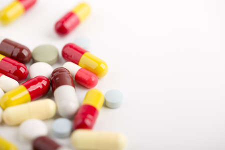 Assorted pharmaceutical medicine pills, tablets and capsules over white background.の写真素材