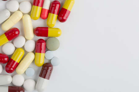Assorted pharmaceutical medicine pills, tablets and capsules over white background.の写真素材