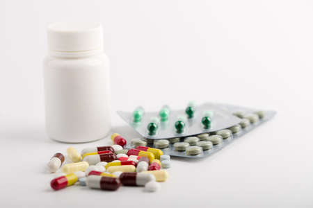 Assorted pharmaceutical medicine pills, tablets and capsules over white background.の写真素材