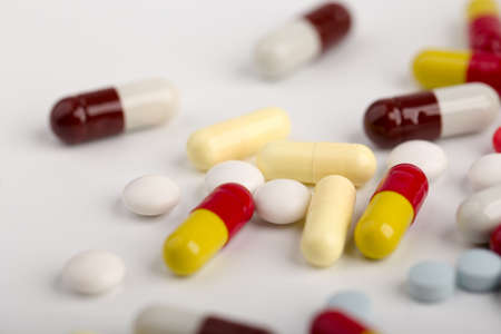 Assorted pharmaceutical medicine pills, tablets and capsules over white background.の写真素材