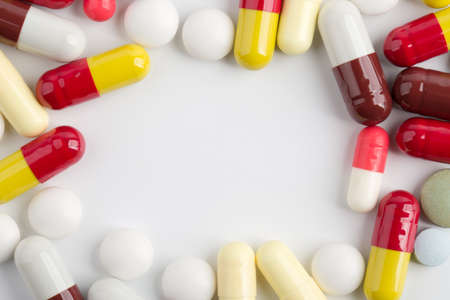 Assorted pharmaceutical medicine pills, tablets and capsules over white background.の写真素材