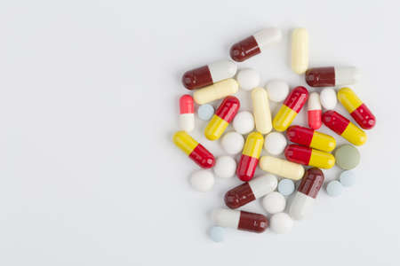 Assorted pharmaceutical medicine pills, tablets and capsules over white background.の写真素材