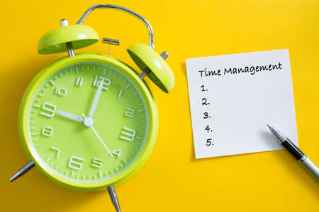 Time management concept. Alarm clock on yellow background.の写真素材