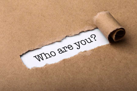 Who Are You Concept word written under torn paper.の写真素材