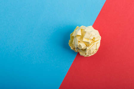 Crumpled paper ball up piece of paper on colored background.の写真素材