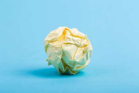 Crumpled paper ball up piece of paper on blue background.の写真素材