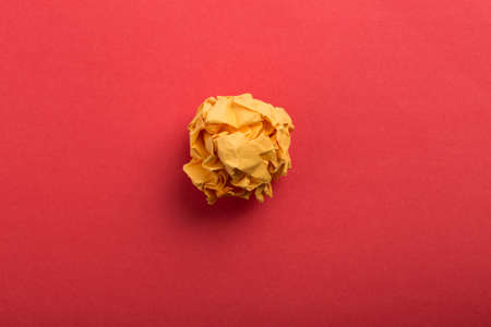 Crumpled paper ball up piece of paper on red background.の写真素材