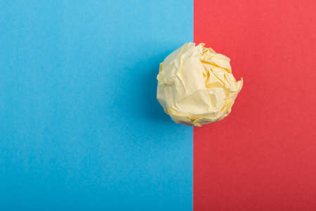Crumpled paper ball up piece of paper on colored background.の写真素材