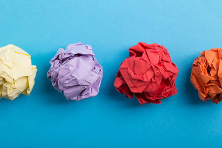 Crumpled paper balls up piece of paper on blue background.の写真素材