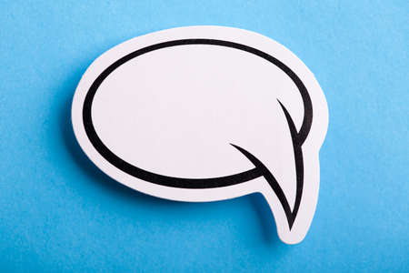 Blank white speech bubble isolated on blue background.の写真素材