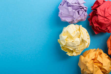Crumpled paper balls up piece of paper on blue background.の写真素材