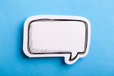 Blank white speech bubble isolated on blue background.の写真素材
