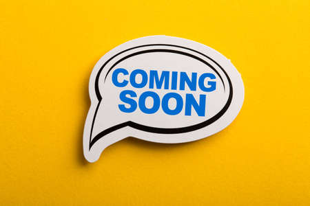 Coming Soon speech bubble isolated on the yellow background.の写真素材