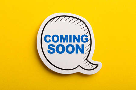 Coming Soon speech bubble isolated on the yellow background.の写真素材