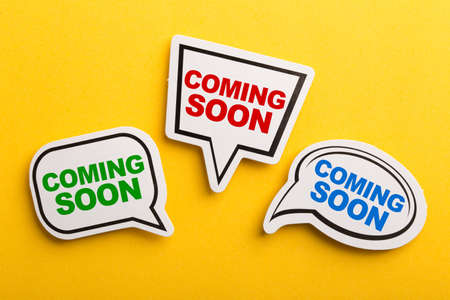 Coming Soon speech bubble isolated on the yellow background.の写真素材