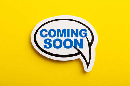 Coming Soon speech bubble isolated on the yellow background.の写真素材