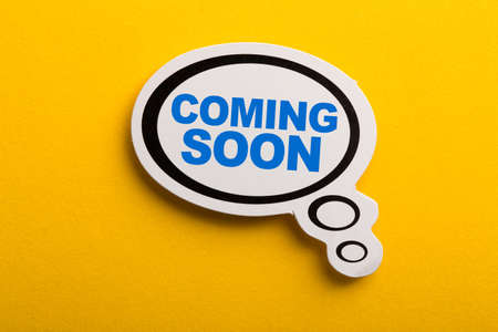 Coming Soon speech bubble isolated on the yellow background.の写真素材
