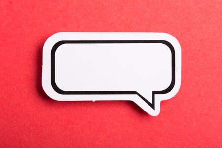 Blank white speech bubble isolated on red background.の写真素材