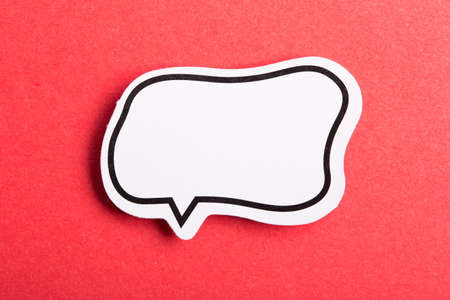 Blank white speech bubble isolated on red background.の写真素材