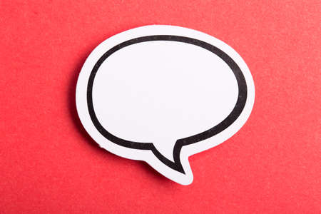 Blank white speech bubble isolated on red background.の写真素材