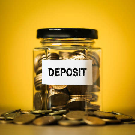 Deposit concept glass jar with a lot of coins inside.の写真素材
