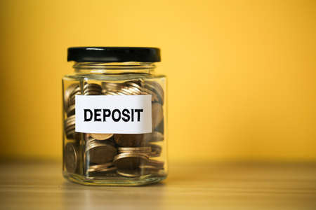 Deposit concept glass jar with a lot of coins inside.の写真素材