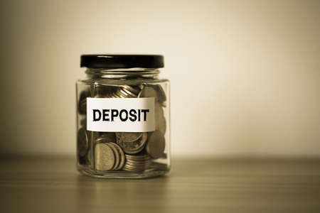 Deposit concept glass jar with a lot of coins inside.の写真素材