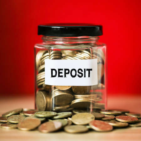 Deposit concept glass jar with a lot of coins inside.の写真素材