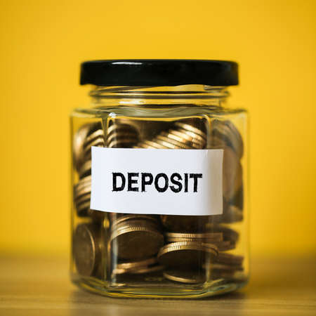Deposit concept glass jar with a lot of coins inside.の写真素材