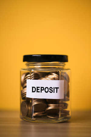 Deposit concept glass jar with a lot of coins inside.の写真素材