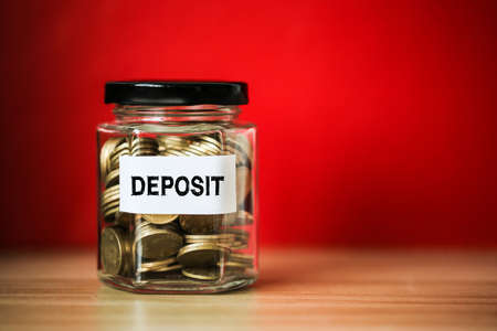 Deposit concept glass jar with a lot of coins inside.の写真素材