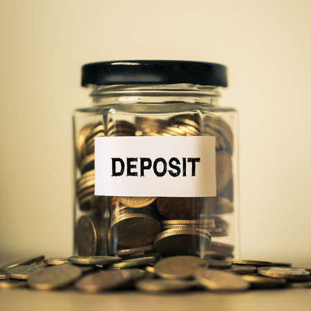 Deposit concept glass jar with a lot of coins inside.の写真素材