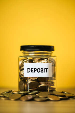 Deposit concept glass jar with a lot of coins inside.の写真素材