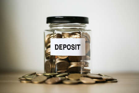 Deposit concept glass jar with a lot of coins inside.の写真素材