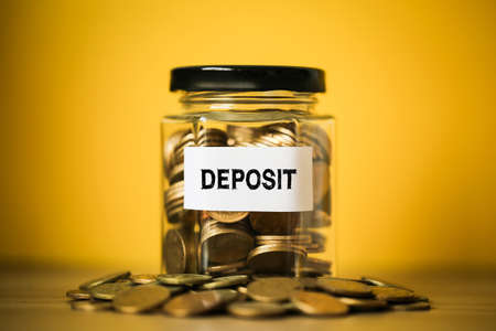 Deposit concept glass jar with a lot of coins inside.の写真素材