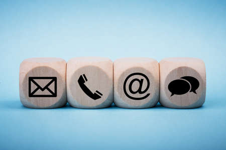 Contact Methods. Close-up of a phone, email, chat and post icons wooden block.の写真素材