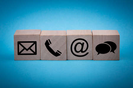 Contact Methods. Close-up of a phone, email, chat and post icons wooden block.の写真素材