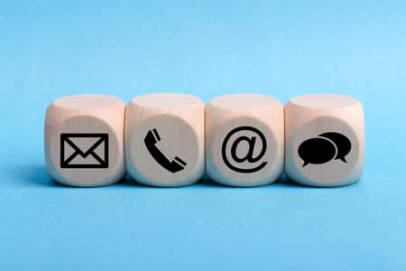 Contact Methods. Close-up of a phone, email, chat and post icons wooden block.の写真素材