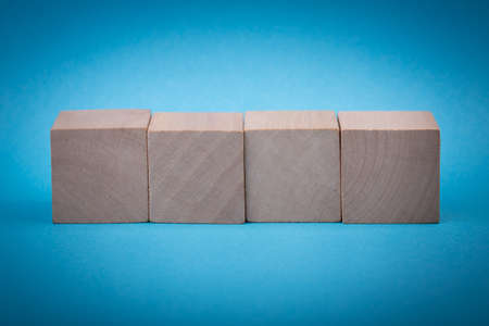 Four blank wooden blocks isolated on color background.の写真素材