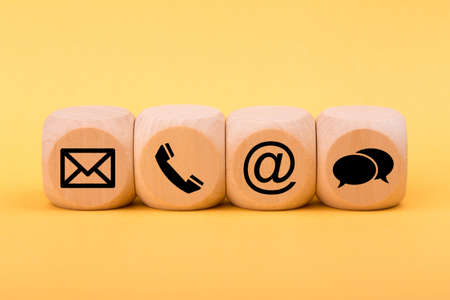 Contact Methods. Close-up of a phone, email, chat and post icons wooden block.の写真素材