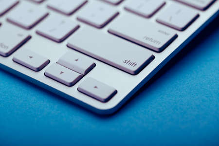 Closeup Shot Of White Keyboard on blue background.の写真素材