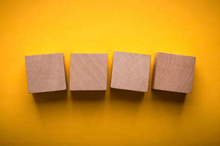 Four blank wooden blocks isolated on color background.の写真素材